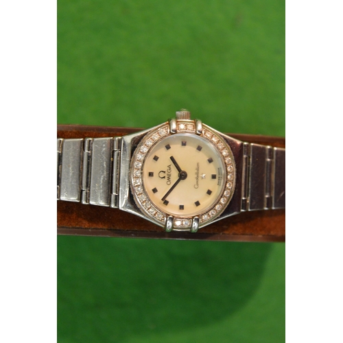 774 - A ladies Omega Constellation stainless steel wrist watch with diamond set bezel.