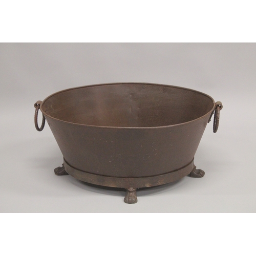 1007 - A LARGE OVAL CAST IRON PLANTER with ring handles on claw feet. 2ft 3ins diameter.