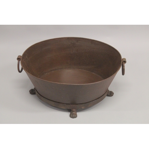 1007 - A LARGE OVAL CAST IRON PLANTER with ring handles on claw feet. 2ft 3ins diameter.