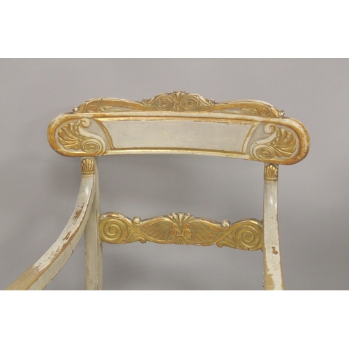 1034D - A PAIR OF CARVED, PAINTED AND PARCEL GILDED OPEN ARMCHAIRS, with floral upholstered overstuffed seat... 