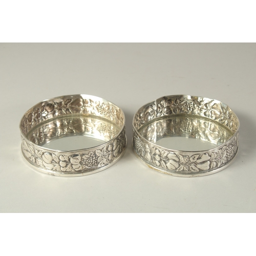 1863 - A PAIR OF .800 SILVER FRUITING VINE COASTERS. 4.5ins diameter.