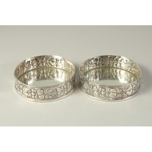 1863 - A PAIR OF .800 SILVER FRUITING VINE COASTERS. 4.5ins diameter.