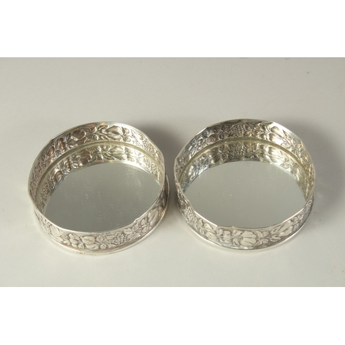 1863 - A PAIR OF .800 SILVER FRUITING VINE COASTERS. 4.5ins diameter.