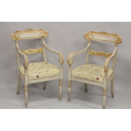 1004 - A PAIR OF CARVED, PAINTED AND PARCEL GILDED OPEN ARMCHAIRS, with floral upholstered overstuffed seat... 