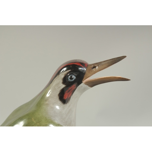 1077 - A MEISSEN GREEN WOODPECKER first modelled by Joachim Kaendler.  Circa. 1880. 26.5cm tall.  Cross swo... 