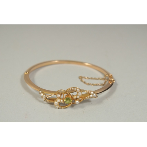 1481 - AN EDWARDIAN GOLD BANGLE set with seed pearls.