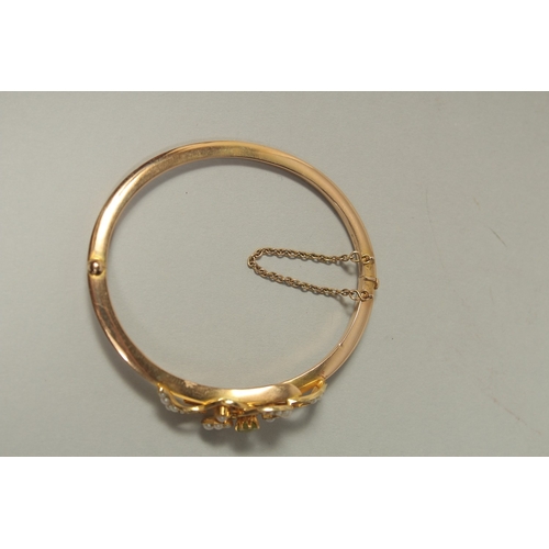 1481 - AN EDWARDIAN GOLD BANGLE set with seed pearls.