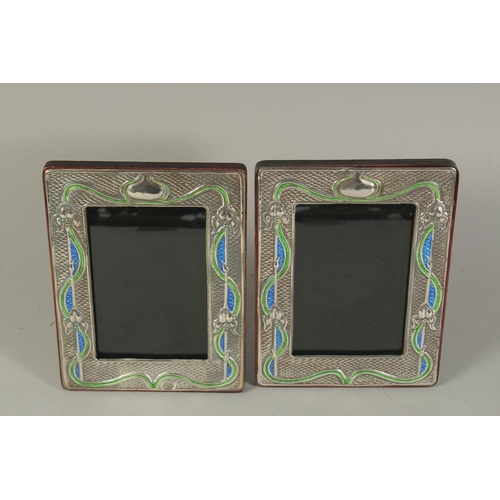 1794 - A PAIR OF ART DECO DESIGN SILVER AND BLUE ENAMEL PHOTOGRAPH FRAMES. 7.5 x 6ins.