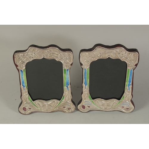 1795 - A PAIR OF ART DECO DESIGN SILVER AND BLUE ENAMEL BUTTERFLY PHOTOGRAPH FRAMES. 8 x 6ins.