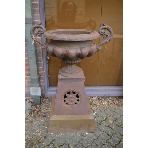 1035A - A GOOD LARGE PAIR OF VICTORIAN STYLE CAST IRON TWIN HANDLED PEDESTAL URNS, on tapering square bases.... 