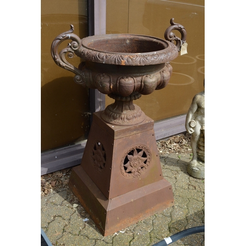 30 - A good large pair of Victorian style cast iron twin handle urns on tapering bases.