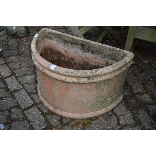 21 - A large pair of terracotta demi-lune planters.