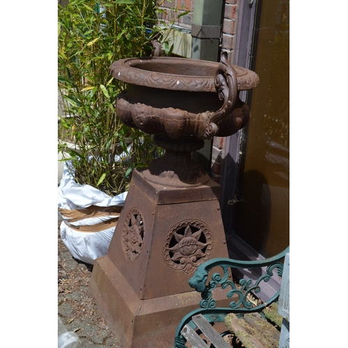 27 - A good large pair of cast iron twin handled urns on pedestal bases.