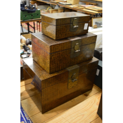 575 - Graduated set of three Chinese storage boxes.