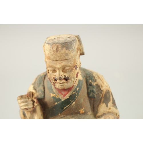 377 - A CHINESE CARVED WOOD SEATED FIGURE, 18cm high.