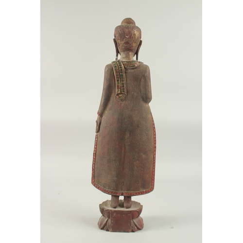 378 - AN INDIAN CARVED WOOD STANDING BUDDHA UPON A LOTUS BASE, with applied coloured glass to the robes, 6... 