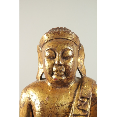 380 - A LARGE GILDED CARVED WOODEN BUDDHA WITH OVAL HARDWOOD STAND, Buddha 52cm high, base 29cm wide, wood... 