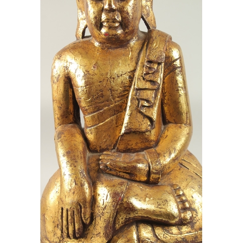 380 - A LARGE GILDED CARVED WOODEN BUDDHA WITH OVAL HARDWOOD STAND, Buddha 52cm high, base 29cm wide, wood... 