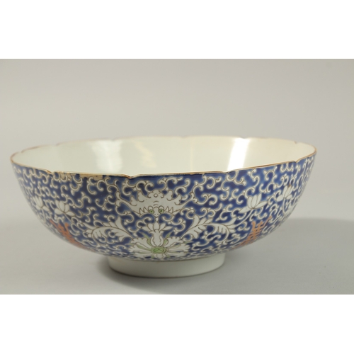 60 - AN EARLY 20TH CENTURY CHINESE BLUE GROUND PORCELAIN BOWL, with enamel-painted bats and floral motifs... 