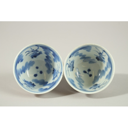 7 - A PAIR OF CHINESE BLUE AND WHITE / CAFE AU LAIT GLAZE PORCELAIN TEA CUPS, the interior with fish dec... 