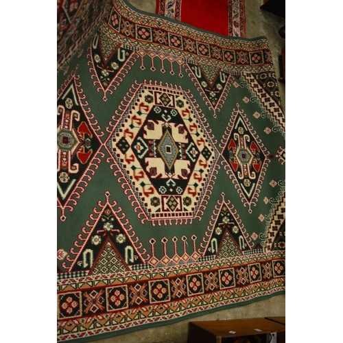 190 - A green ground machine made rug, 225cm x 160cm.