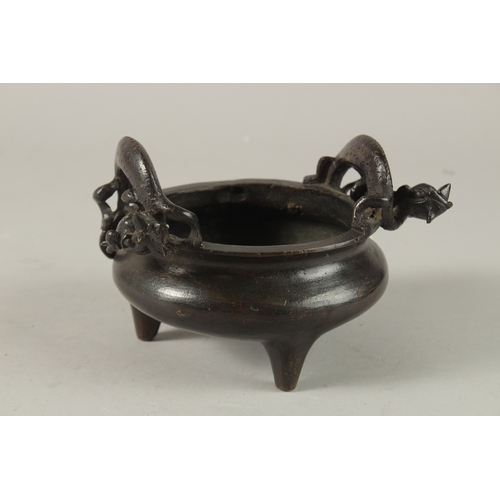 14 - A CHINESE BRONZE TRIPOD CENSER, with twin dragon-form handles, the base with character mark, 17.5cm ... 