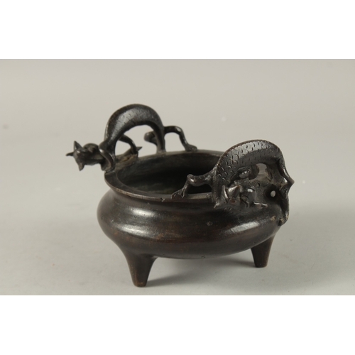 14 - A CHINESE BRONZE TRIPOD CENSER, with twin dragon-form handles, the base with character mark, 17.5cm ... 