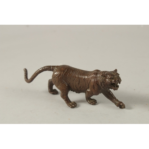 24 - A BRONZE OKIMONO OF A TIGER, 15cm long.