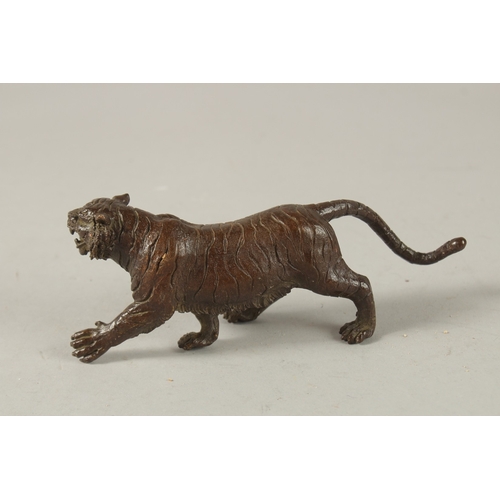 24 - A BRONZE OKIMONO OF A TIGER, 15cm long.