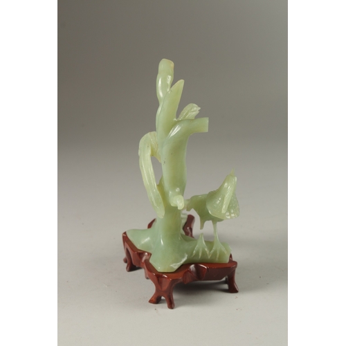 3 - A CHINESE CARVED JADE GROUP ON HARDWOOD STAND, the group carved with pea hens on tree branches, jade... 