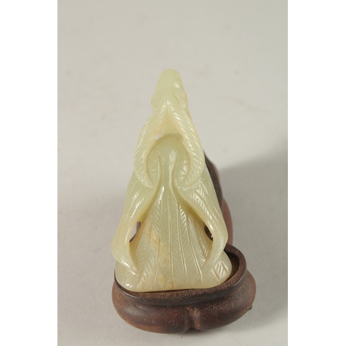 33 - A CHINESE CARVED JADE FIGURE OF A MYTHICAL CREATURE on a wooden stand, jade 10cm long.