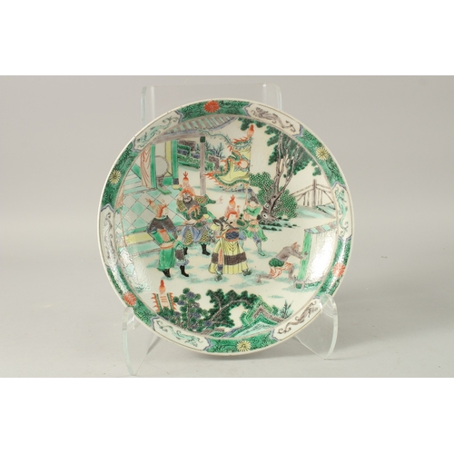 37 - A CHINESE FAMILLE VERTE PORCELAIN PLATE, painted with figures in a courtyard, the base with symbol m... 