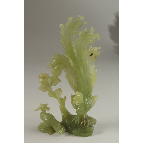 4 - A CHINESE CARVED JADE GROUP ON HARDWOOD STAND, carved in the form of a peacock and pea hen on a rock... 