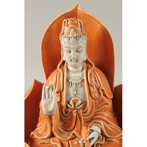 44 - A LARGE CHINESE PART-GLAZED PORCELAIN GUANYIN SITTING ON A LOTUS BASE, 31.5cm high.