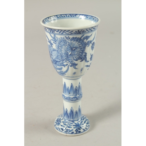 50 - A CHINESE KANGXI PERIOD BLUE AND WHITE PORCELAIN STEM CUP, finely painted with native flora, 15.5cm ... 