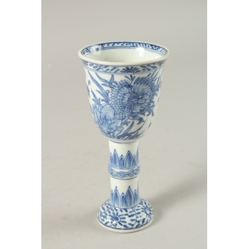 50 - A CHINESE KANGXI PERIOD BLUE AND WHITE PORCELAIN STEM CUP, finely painted with native flora, 15.5cm ... 