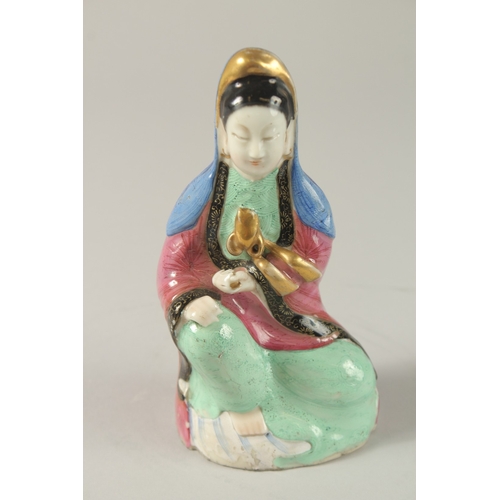 51 - A CHINESE POLYCHROME PORCELAIN GUANYIN FIGURE, in seated position with gilded highlights, 15cm high.