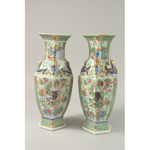 52 - A PAIR OF CHINESE CANTON FAMILLE ROSE PORCELAIN HEXAGONAL VASES, painted with panels of figures and ... 