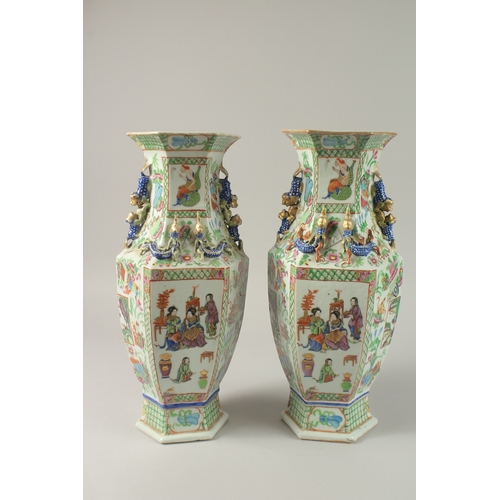 52 - A PAIR OF CHINESE CANTON FAMILLE ROSE PORCELAIN HEXAGONAL VASES, painted with panels of figures and ... 