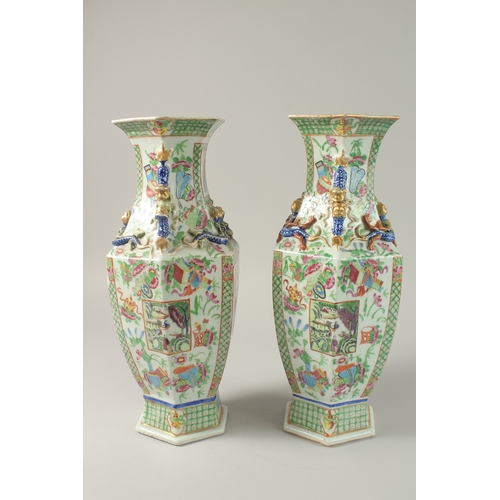 52 - A PAIR OF CHINESE CANTON FAMILLE ROSE PORCELAIN HEXAGONAL VASES, painted with panels of figures and ... 