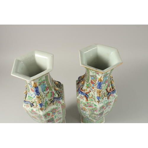 52 - A PAIR OF CHINESE CANTON FAMILLE ROSE PORCELAIN HEXAGONAL VASES, painted with panels of figures and ... 