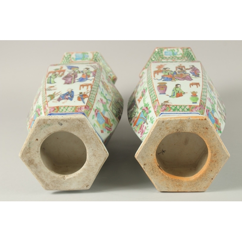 52 - A PAIR OF CHINESE CANTON FAMILLE ROSE PORCELAIN HEXAGONAL VASES, painted with panels of figures and ... 