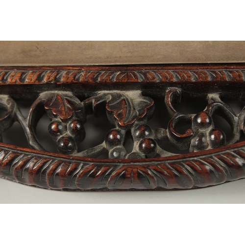 68 - A CHINESE CARVED OPENWORKED HARDWOOD DESK STAND with two glass inkwells and brush rest, 31cm x 23cm.