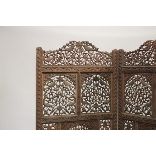 99 - A FINE INDIAN CARVED SANDALWOOD OPENWORKED FOUR PANEL SCREEN, with carved birds and foliate designs,... 