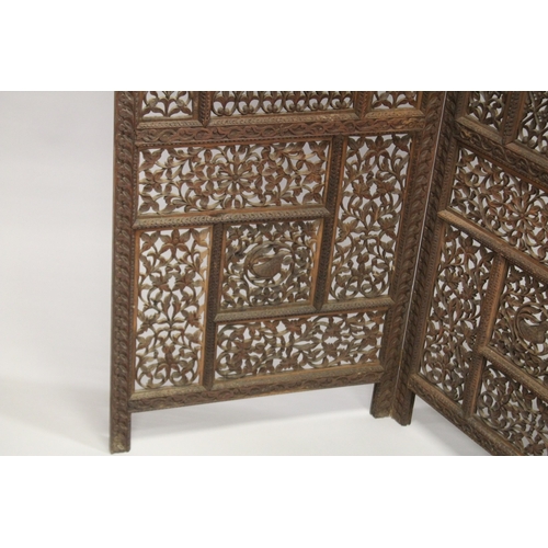 99 - A FINE INDIAN CARVED SANDALWOOD OPENWORKED FOUR PANEL SCREEN, with carved birds and foliate designs,... 