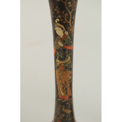 315 - A PAIR OF PERSIAN QAJAR LACQUERED WOOD CANDLESTICKS, decorated with figures and flora, 26.5cm high.