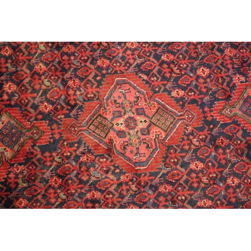 1001 - A PERSIAN CARPET, blue ground with stylised floral decoration. 310cms x 138cms.