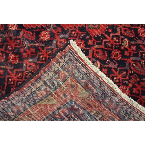 1001 - A PERSIAN CARPET, blue ground with stylised floral decoration. 310cms x 138cms.