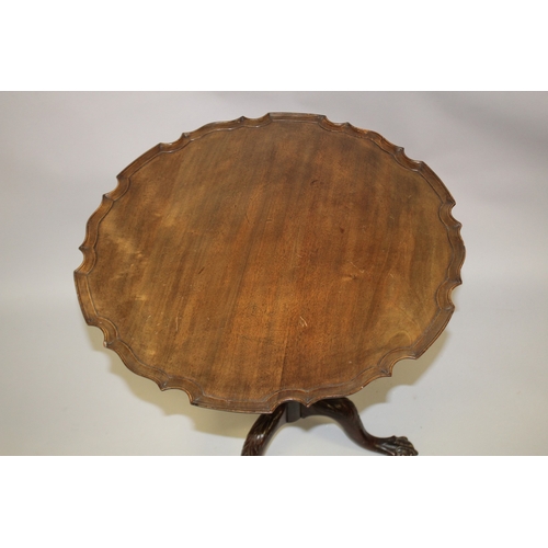 1029 - A GEORGE III MAHOGANY TILT TOP TRIPOD TABLE with pie crust top, carved and turned column support, on... 