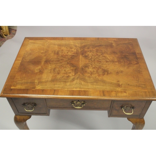 1043 - A GEORGE III DESIGN WALNUT LOW BOY, with a central drawer flanked by a pair of deep drawers on cabri... 